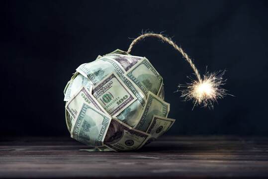 L'inquiétude face à l'inflation est-elle en train de monter? Une bombe représentant l'inflation, constituée de billets de 100 dollars US, en train de fumer et sur le point d'exploser sur l'économie mondiale.