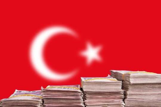 What Inflation Feels Like in Real Life: the Case of Turkey the Turkish lira notes after a historic 15% crash stacked in front of the Turkish flag