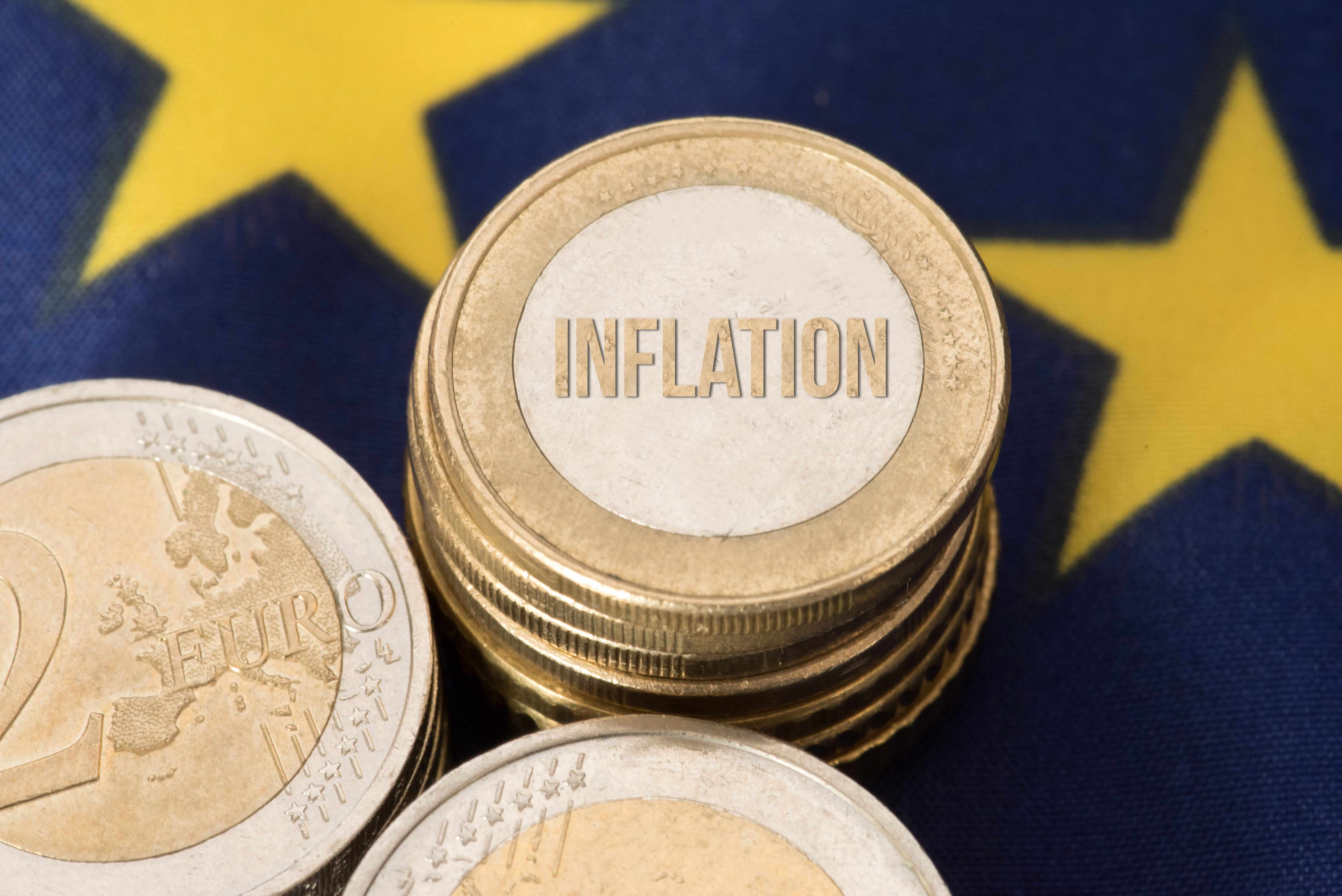 2-Euro-Münze und Euro-Inflationsmünze auf der EU-Flagge